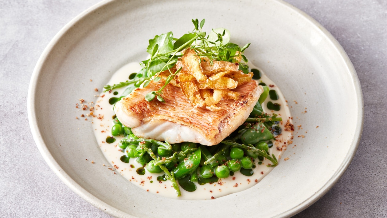 Roodbaars met groenten, krokante aardappelschillen en witte wijnsaus met bieslook